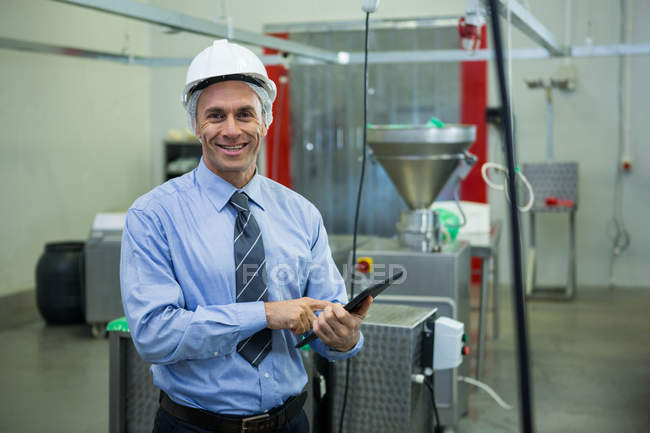 Portrait of smiling technician with digital tablet at meat factory — Stock Photo
