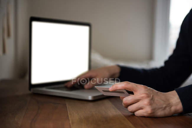 Homme faisant des achats en ligne sur ordinateur portable à la maison — Photo de stock
