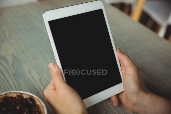 Hand of woman using digital tablet in cafe — Stock Photo