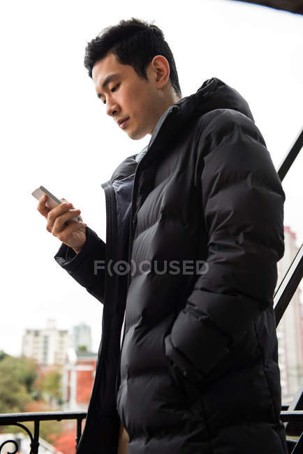 Человек с мобильного телефона на балконе — стоковое фото