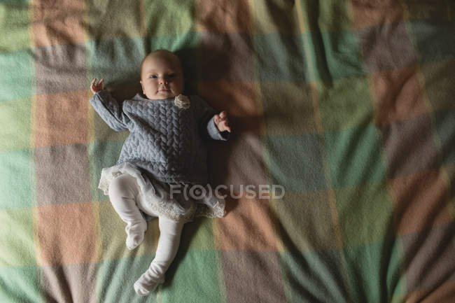 Niedliches Baby auf dem Bett liegend im Schlafzimmer zu Hause, Blick über den Kopf — Stockfoto