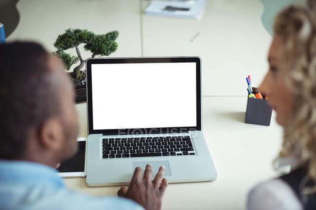 Крупним планом бізнес-керівники обговорюють ноутбук в офісі — стокове фото
