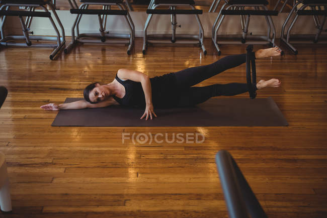 Donna che pratica pilates sul tappetino da ginnastica in palestra — Foto stock