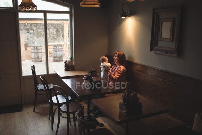 Felice madre che gioca con il bambino in caffetteria — Foto stock