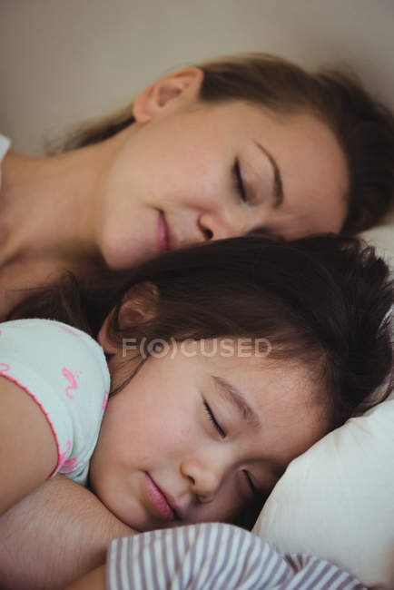 Mãe e filha dormindo juntas no quarto em casa — Fotografia de Stock