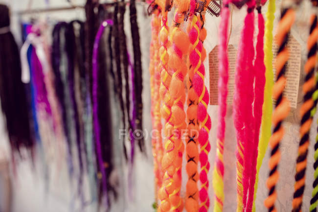 Assorted colourful artificial dreadlocks in shop — Stock Photo
