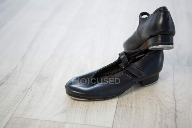 Primer plano de los zapatos de grifo en el suelo de madera - foto de stock