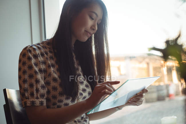 Beautiful woman using futuristic digital tablet at cafe — Stock Photo