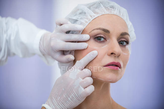 Доктор вивчення жіноче обличчя пацієнта для косметичне лікування в клініці — стокове фото