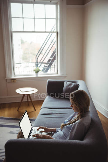 Женщина с ноутбуком в гостиной на дому — стоковое фото