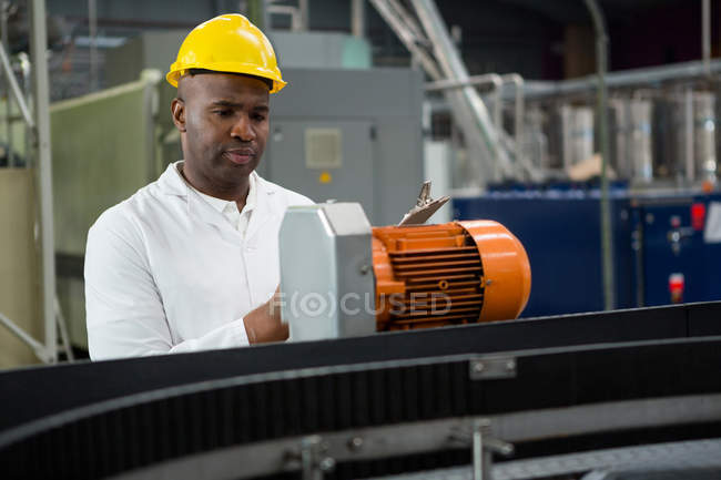 Engineer inspecting machines at juice factory — Stock Photo