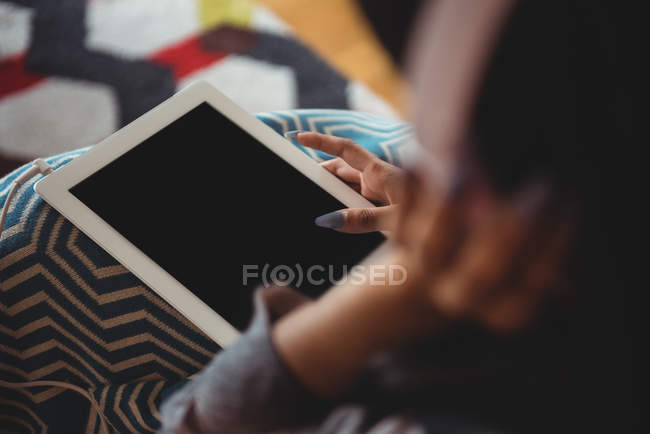 Mid section of woman using digital tablet in living room at home — Stock Photo