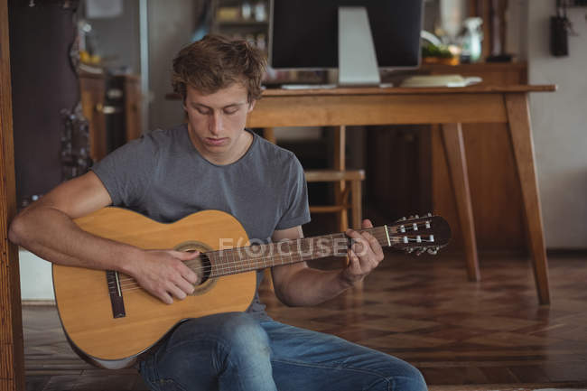 Чоловік грає на гітарі вдома — стокове фото