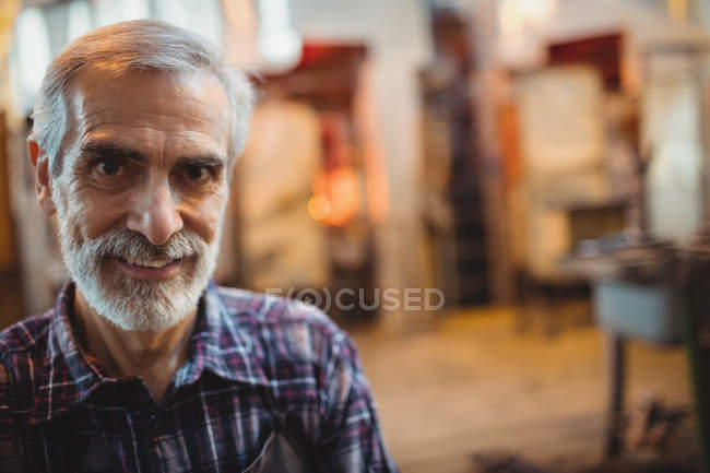 Portrait of glassblower standing at glassblowing factory — Stock Photo