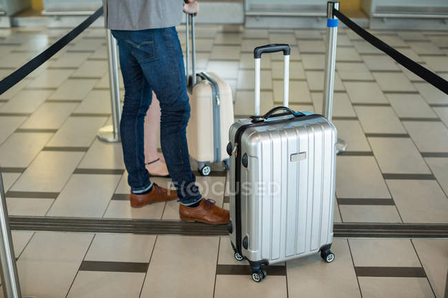 Empresários esperando na fila em um balcão de check-in com bagagem no terminal do aeroporto — Fotografia de Stock