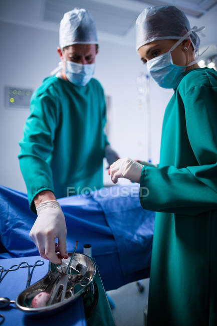 Chirurgiens masculins et féminins effectuant une opération dans le théâtre d'opération de l'hôpital — Photo de stock