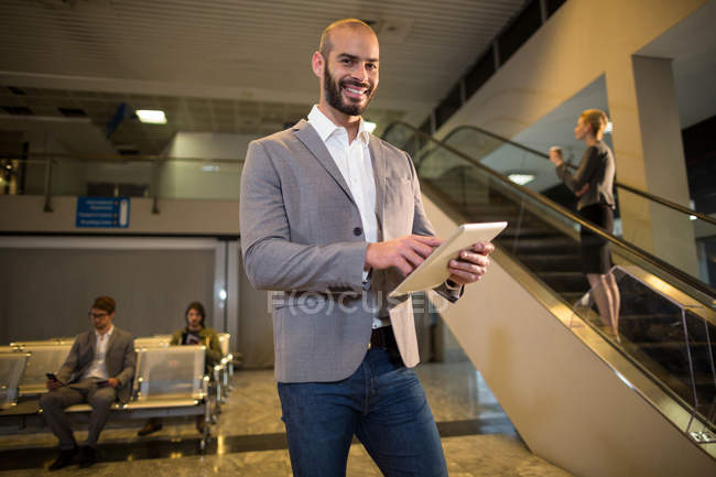 Homme d'affaires utilisant une tablette numérique à l'aéroport — Photo de stock