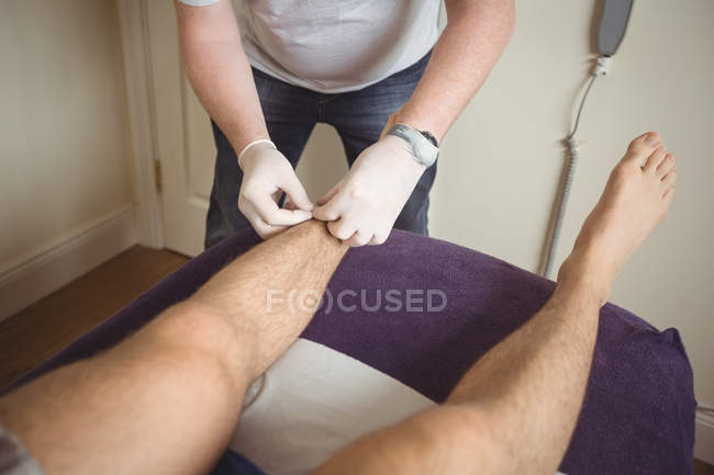 Nahaufnahme des Physiotherapeuten, der trockene Nadeln am Bein eines Patienten in der Klinik durchführt — Stockfoto