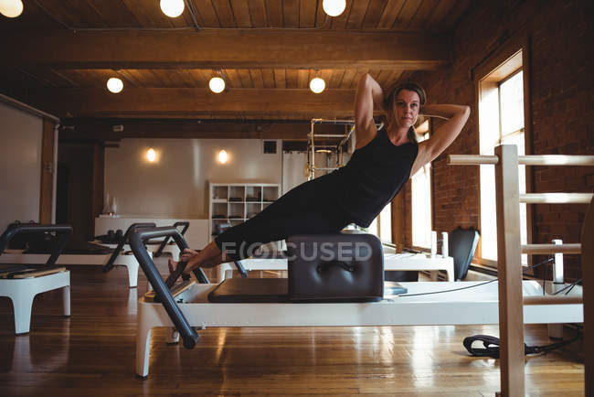 Determined mid adult woman practicing pilates in fitness studio — Stock Photo