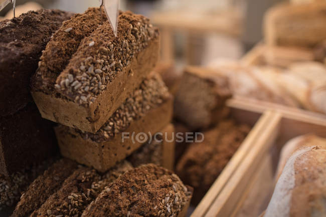 Primer plano del pan de centeno guardado en el mostrador de panadería en el supermercado - foto de stock
