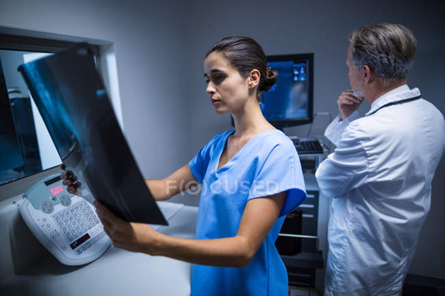 Enfermeira a examinar um raio-X no hospital — Fotografia de Stock