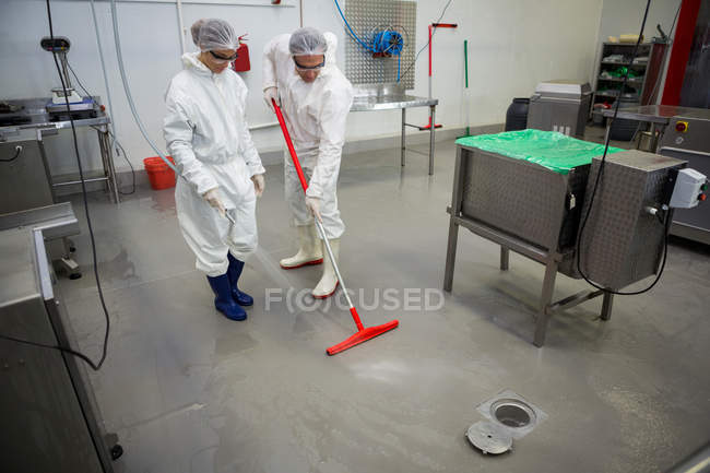 Il personale pulisce il pavimento in fabbrica di carne — Foto stock