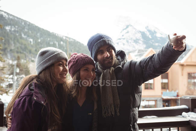 Amigos divirtiéndose y tomando una selfie usando el teléfono móvil - foto de stock