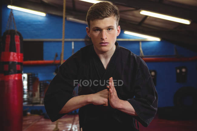 Junge erwachsene Karatespieler führen Karate-Haltung im Fitnessstudio vor — Stockfoto