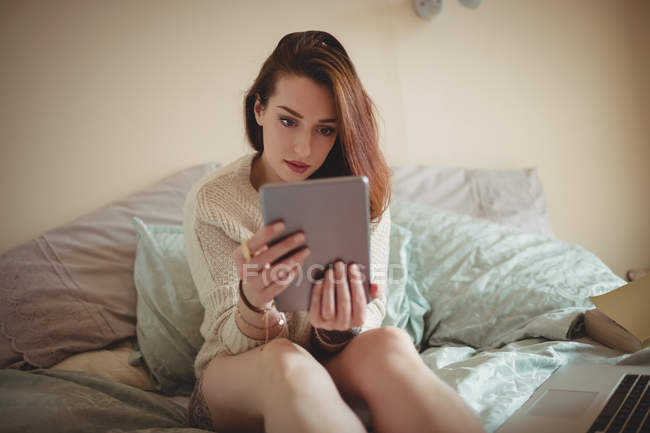 Bella donna che utilizza tablet digitale sul letto a casa — Foto stock