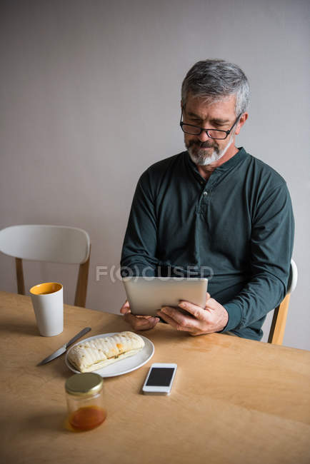 Meados da seção do homem usando tablet digital em casa — Fotografia de Stock