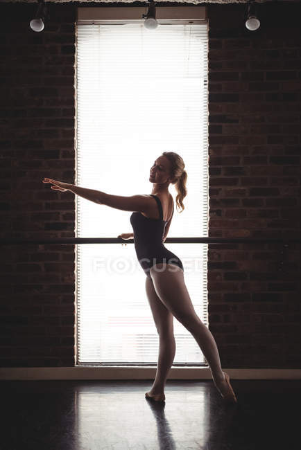 Bailarina praticando dança de balé no barre no estúdio de balé — Fotografia de Stock