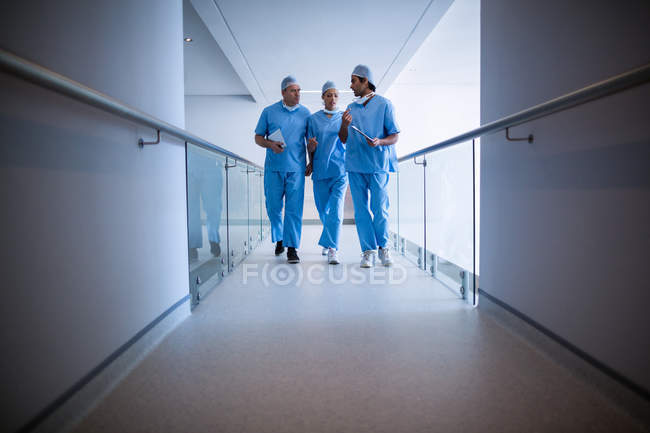 Cirujanos interactuando entre sí en el pasillo del hospital - foto de stock