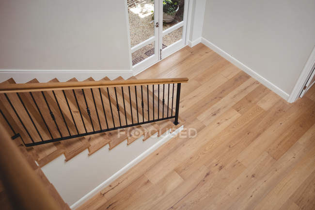 Intérieur de la maison avec plancher en bois et escalier avec murs blancs — Photo de stock