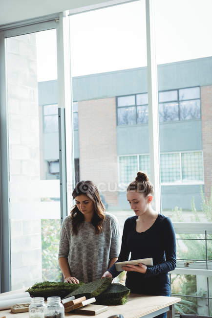 Бизнес-руководители, изучающие искусственное покрытие при использовании цифрового планшета в офисе — стоковое фото