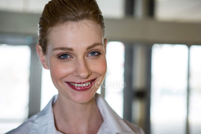 Retrato de una mujer sonriente en la terminal del aeropuerto - foto de stock