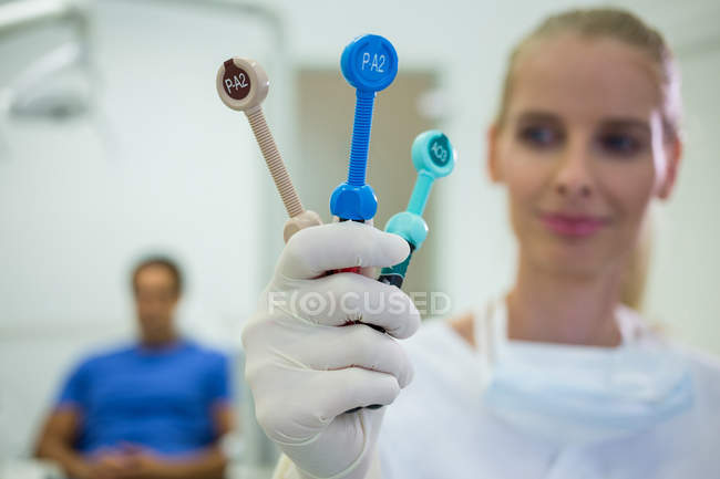 Dentista segurando ferramentas dentárias na clínica — Fotografia de Stock