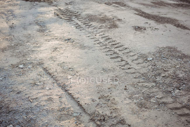 Close-up de pista de pneus na lama no local de construção — Fotografia de Stock