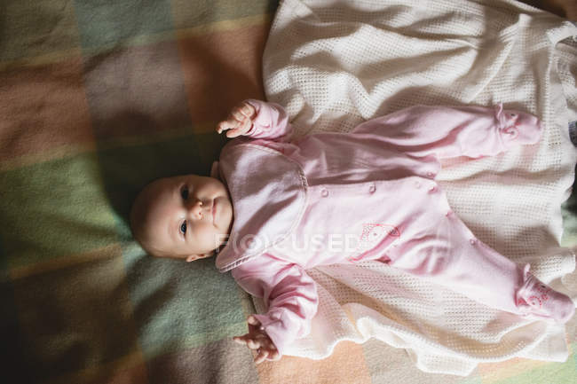 Милый ребенок лежит на кровати в спальне дома — стоковое фото