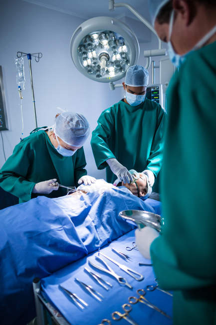 Grupo de cirurgiões que realizam operação no teatro de operação do hospital — Fotografia de Stock