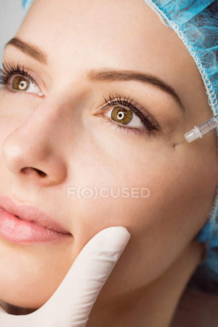 Close-up da doente do sexo feminino a receber injeção facial na clínica — Fotografia de Stock
