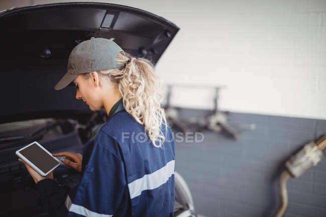 Жінка-механік використовує цифровий планшет у ремонті гаража — стокове фото
