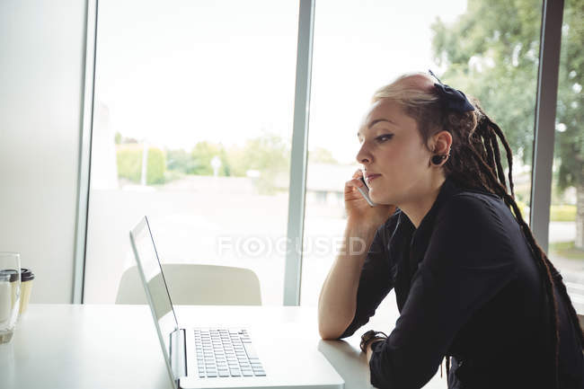 Mujer hablando por teléfono móvil en la cafetería - foto de stock