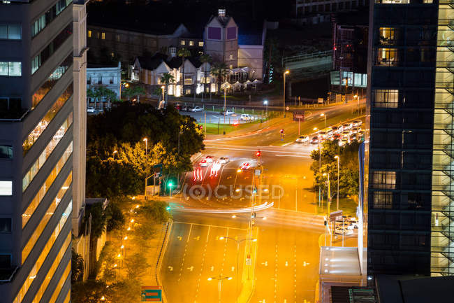 Aerial view of street and office buildings in business district at night — Stock Photo