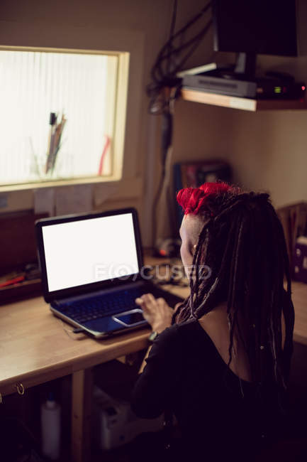 Cabeleireiro feminino usando laptop na loja dreadlocks — Fotografia de Stock