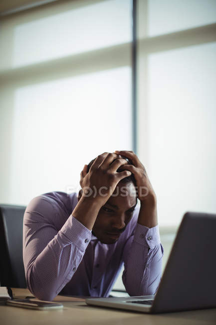 Frustrated business executive working on laptop in office — Stock Photo