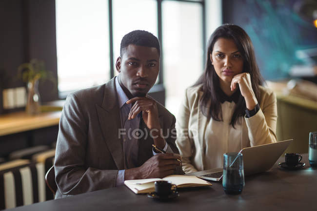 Портрет бизнесмена и коллеги за столом в офисе — стоковое фото
