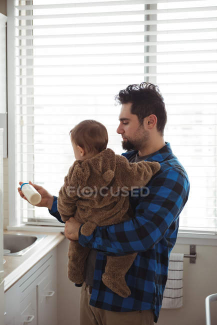 Padre preparare il latte per il suo bambino in cucina a casa — Foto stock