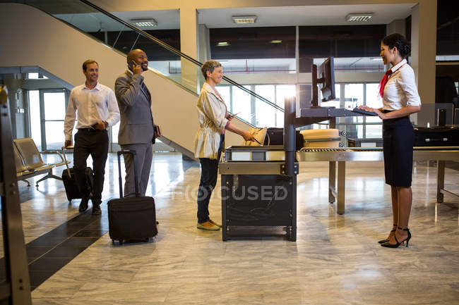 Пасажири, які стоять в черзі на перевірку безпеки в терміналі аеропорту — стокове фото