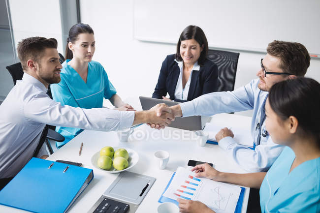 Les médecins se serrent la main lors d'une réunion dans la salle de conférence — Photo de stock