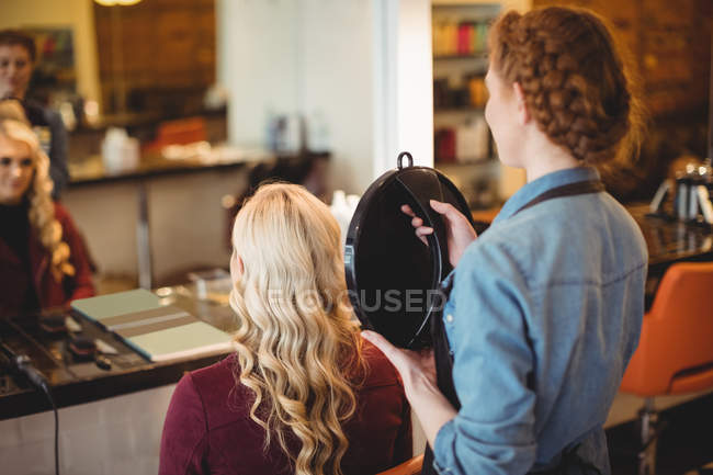 Peluquería femenina clientes de peinado cabello en salón - foto de stock